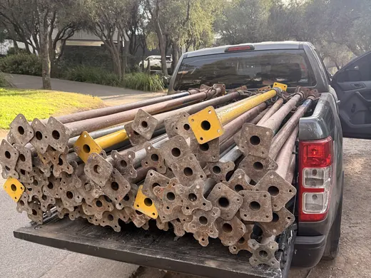 Puntales cargados en la caja de una camioneta, listos para entregar en obra